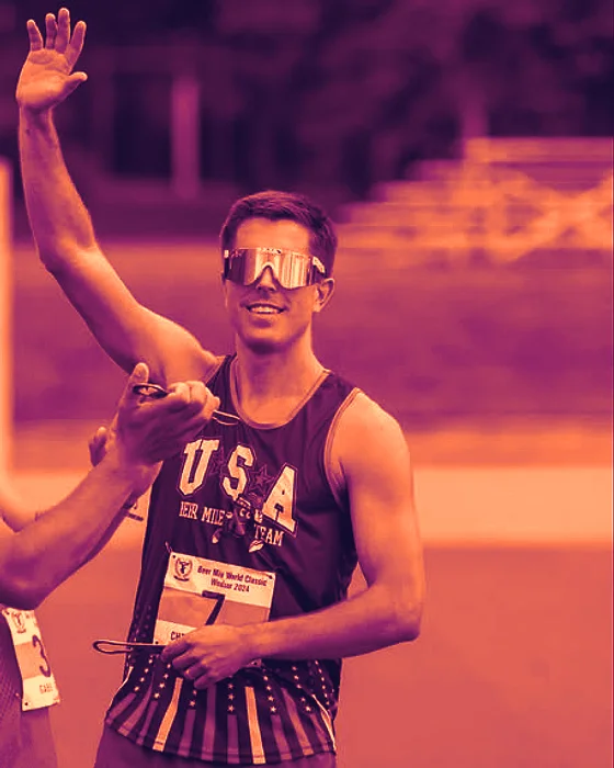 Chris Robertson in mirrored shades and a USA Beer Mile Team singlet, going for a high five at the 2024 Beer Mile World Classic