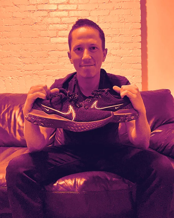 Mike Arnold holding up a pair of running shoes